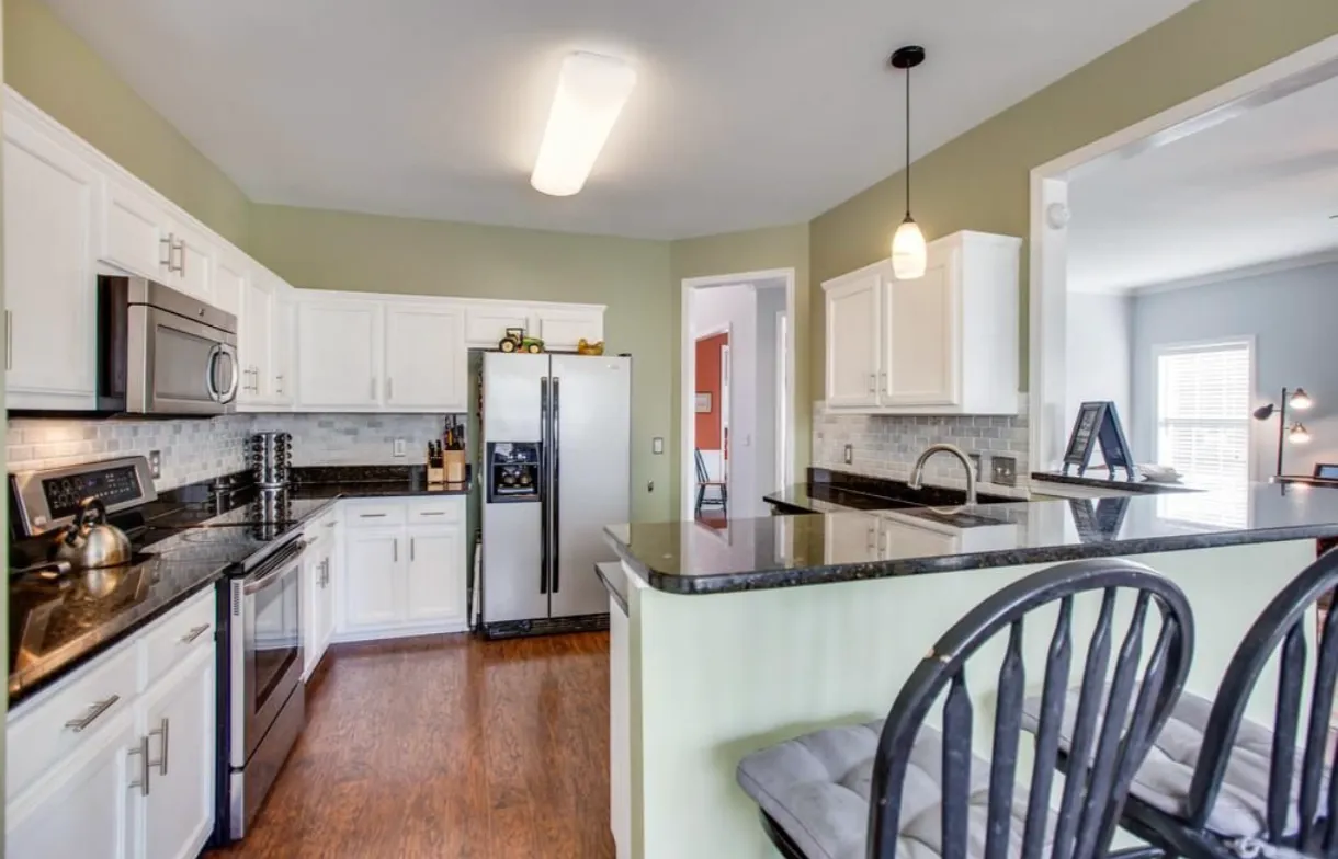 Kitchen island with seating and range hood in a Northern Colorado kitchen remodel by Blue Springs Construction