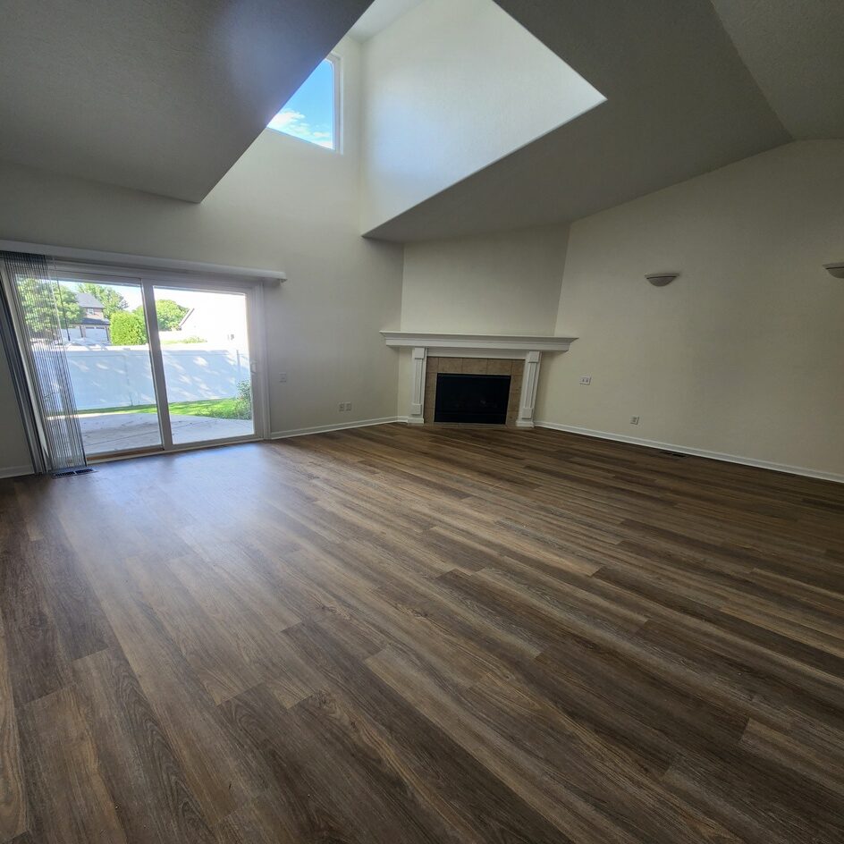 Vaulted living room with wood accent wall, Northern Colorado remodel by Blue Springs Construction