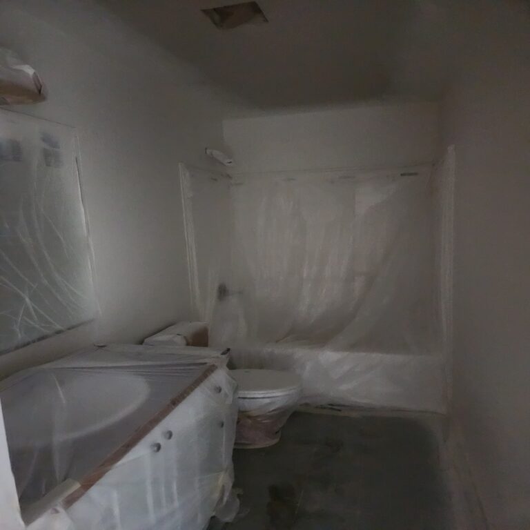 Bathroom masked in plastic for spraying during an interior repaint