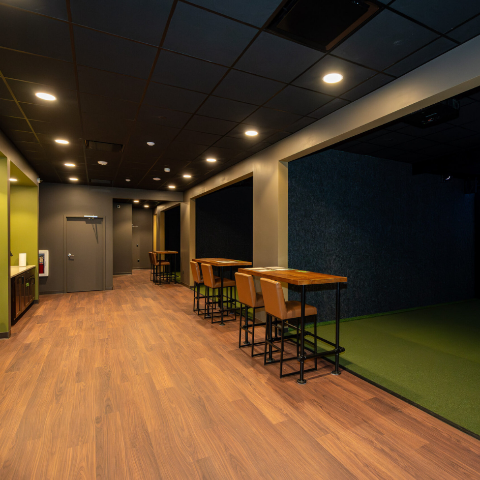 Simulator bays and lounge seating at The Back Nine indoor golf in Timnath, Colorado, completed by Blue Springs Construction