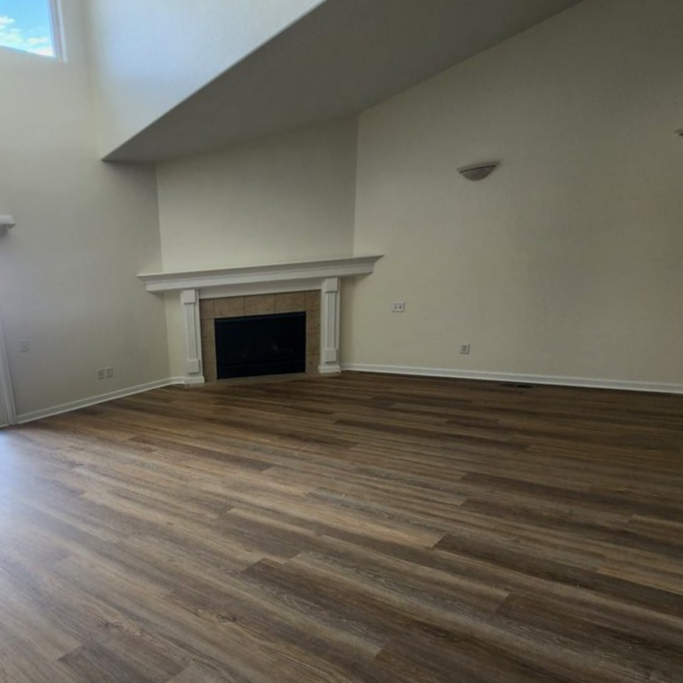 Finished living room with new wood flooring and a rebuilt fireplace surround