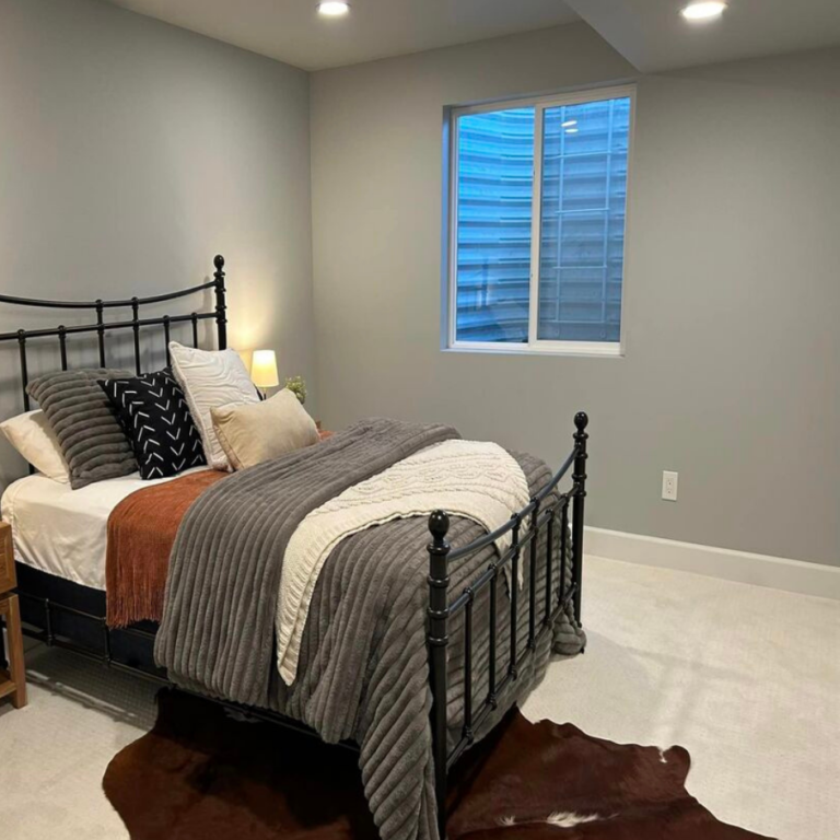 Finished bedroom with an iron bed frame and new window trim