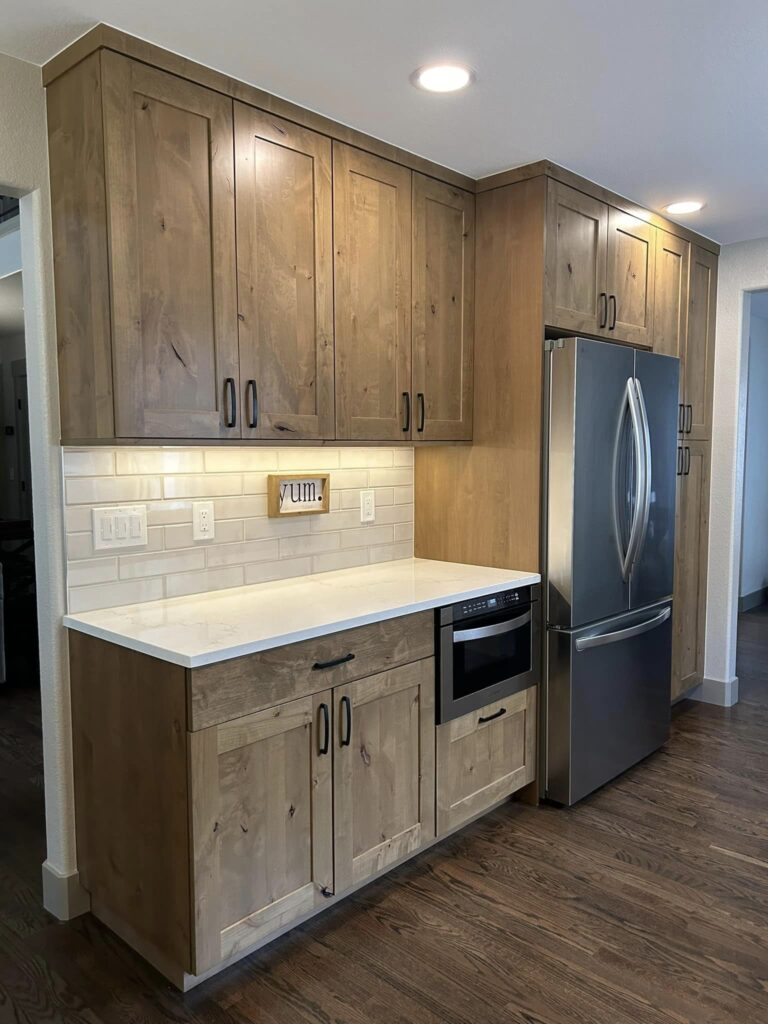 Finished kitchen with knotty alder cabinetry and quartz counters, Windsor, Colorado remodel by Blue Springs Construction