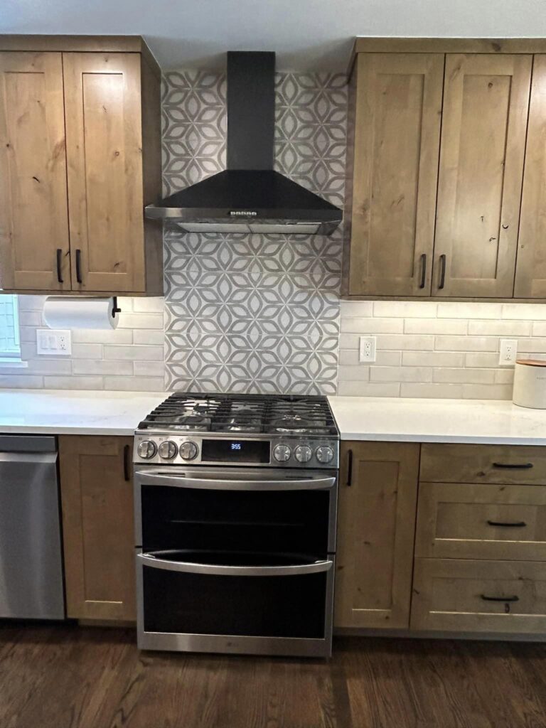 Knotty alder kitchen with gas range, patterned tile splashback and wall mounted extraction, Windsor remodel