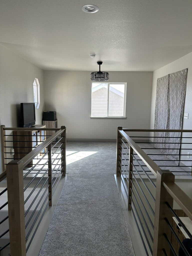 Opened-up upper landing with custom horizontal steel rail